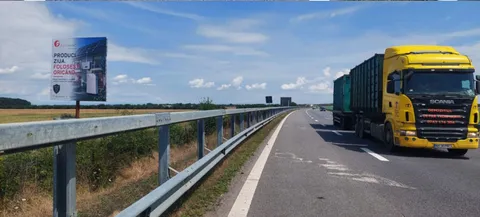 Panou publicitar mare format 14x14 m Mora Group pe Autostrada A3 Bucuresti-Ploiesti — unipol care domina campul vizual langa un camion articulat in trafic, dovada de scara pentru dimensiune
